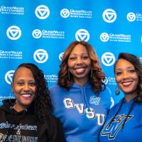 Three women posing in front of GV back drop